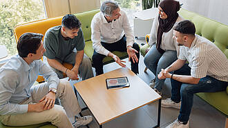 Ein Professor spricht mit einer kleinen Gruppe von Studierenden