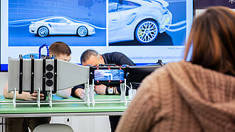 Zwei Studierende und ein Professor, des Bachelorstudiengangs Allgemeiner Maschinenbau arbeiten an einem Modell 