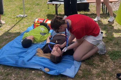 Studierende des Studiengangs Physician Assistant zeigen Besucherinnen und Besuchern auf der Landesgartenschau wie eine Reanimation funktioniert.
