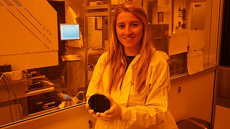 Im Reinraumlabor der Hochschule Aalen ist Selina Burkert tätig. Dort kommt spezielles Gelblicht zum Einsatz, das gefiltert wird, um zu vermeiden, dass empfindliche Materialien durch UV-Licht unbeabsichtigt vorzeitig aushärten.