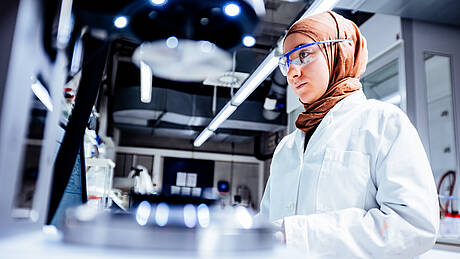 Eine Studentin aus dem Masterstudiengang Angewandte Oberflächen und Materialwissenschaften arbeitet im Labor