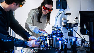Zwei Studierende aus dem Bachelorstudiengang Optical Engineering arbeiten an einem Laser.