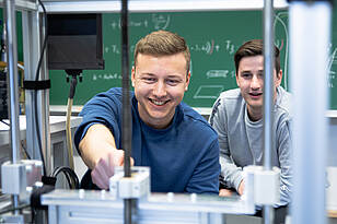 Zwei Studenten aus dem Bachelorstudiengang Mechatronik kompakt durch Anrechnung arbeiten an einer Maschine.