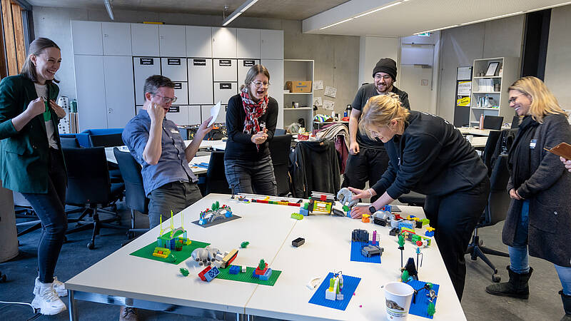 Lehrende nehmen an einem LEGO® Serious Play Workshop teil und entwickeln gemeinsam Modelle.