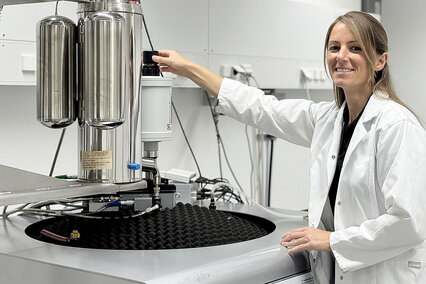 Kathrin Geiger, eine junge Frau mit langen, dunkelblonden Haaren und gekleidet in einem weißen Kittel, steht im Institut für Materialforschung der Hochschule Aalen an einem Vibrationsmagnetometer. Die Masterandin untersucht Kathrin Geiger die magnetischen Eigenschaften ihrer Materialproben. Die Masterandin forscht am Institut für Materialforschung Aalen (IMFAA) der Hochschule Aalen an neuen Magnetwerkstoffe mit weniger kritischen Rohstoffen.