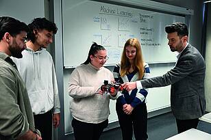 Besprechung zwischen Professor und Studierenden aus dem Bachelorstudiengang Wirtschaftsinformatik