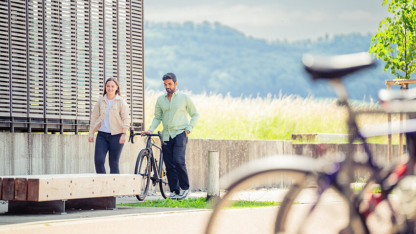 Außenbereich am Burren, zwei Studierende der Hochschule Aalen mit Fahrrad