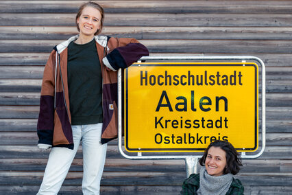 Bild mit zwei Frauen vor dem Ortsschild "Hochschulstadt Aalen"
