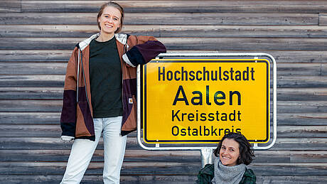 Bild mit zwei Frauen vor dem Ortsschild "Hochschulstadt Aalen"