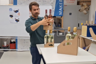 Student stapelt das im Makerspace gebaute Shelf-Ready-Packaging