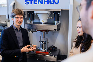 Professor und Studierende aus dem Masterstudiengang Produktentwicklung und Fertigung arbeiten an einer Maschine