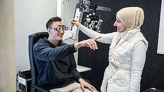 Studierende aus dem Bachelorstudiengang Augenoptik / Optometrie führen einen Sehtest durch