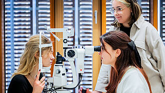Studierende aus dem Bachelorstudiengang Augenoptik / Optometrie führen einen Sehtest durch