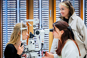 Studierende aus dem Bachelorstudiengang Augenoptik / Optometrie führen einen Sehtest durch