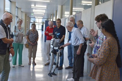 Die Alumni werden vom humanoiden Roboter begrüßt
