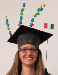 Foto: Frau mit Bachelor-Hut, welcher bunt verziert ist
