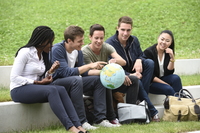 Foto: Studenten spielen im Freien mit einer Weltkugel