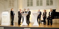 Foto: Prof. Dr.-Ing. Bernhard Höfig und Prof. Dr.-Ing. Peter Eichinger mit neu berufenen Professorinnen und Professoren auf einer Bühne