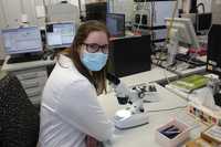 Foto: Studentin sitzt im Labor vor einem Mikroskop
