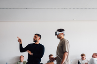 Ein Student (rechts) probiert die Apple Vision Pro aus, daneben Emanuele Frisi, Sales Director der Porsche Group (links). 